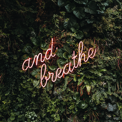 A neon sign that reads "and breathe" A neon sign that reads "and breathe"