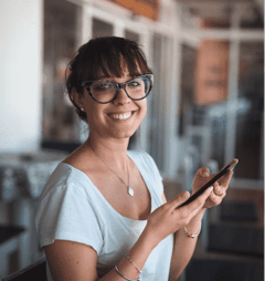 Woman smiling and holding her cell phone