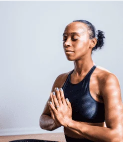 Woman in athletic gear meditating